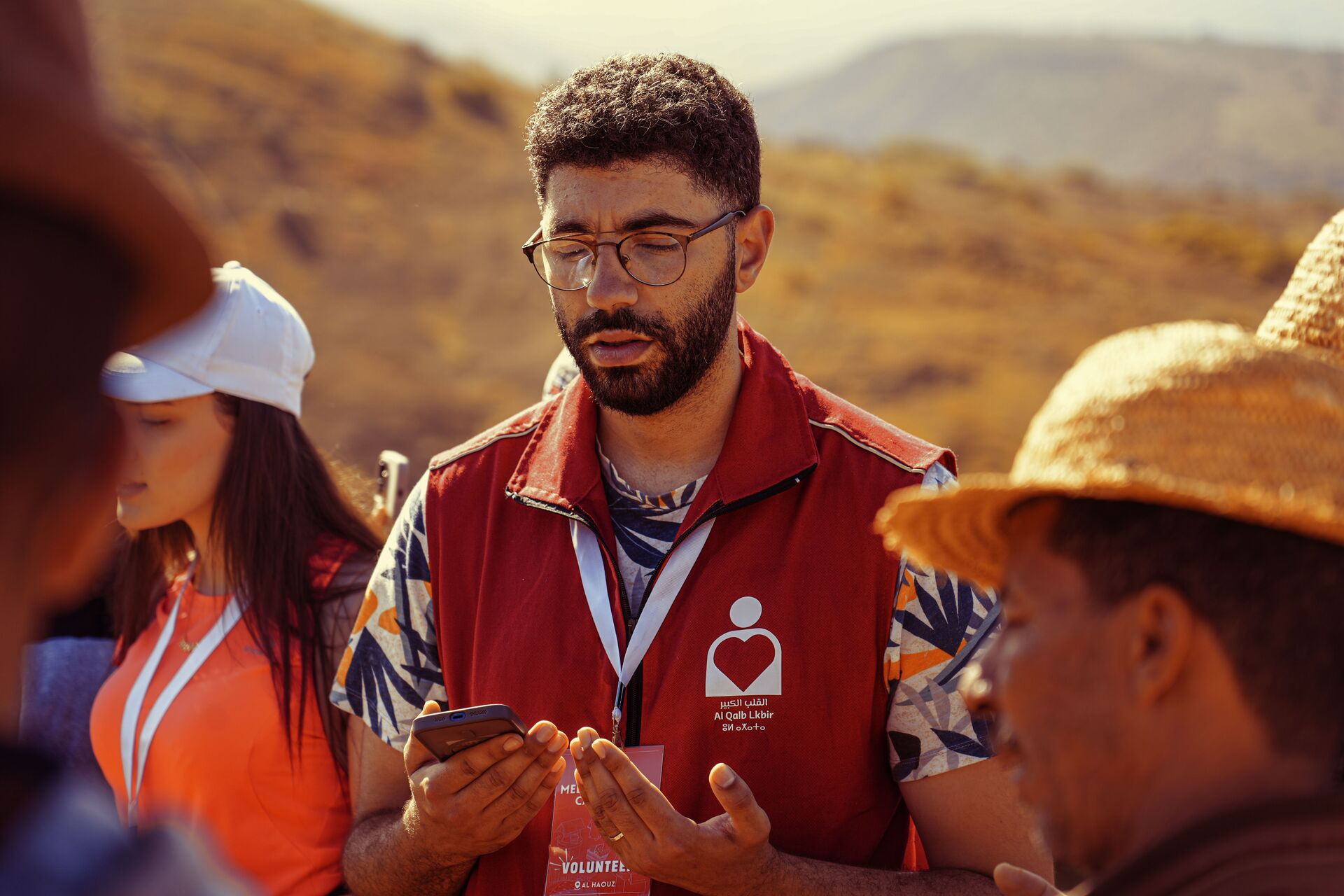 A volunteer coordinating with a group in a rural landscape